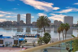 a view of a river with a city and a boat at Cairo Homes Nile View Studios Manial in Cairo