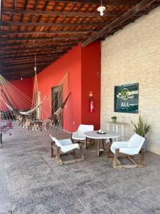 a patio with chairs and a table and a hammock at Allmedhouse in São Luís