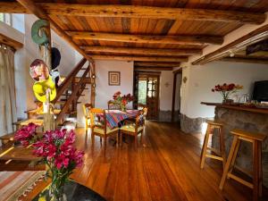 a living room with a table and chairs and a staircase at Casa Nuestra - Room with Private Bathroom in Shared House in Urubamba