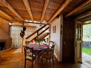a dining room with a table and chairs and wooden ceilings at Casa Nuestra - Room with Private Bathroom in Shared House in Urubamba +6 photos