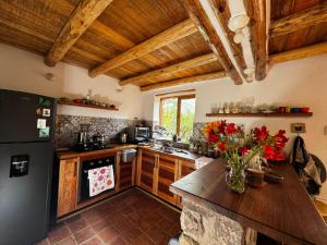 a kitchen with wooden cabinets and a black refrigerator at Casa Nuestra - Room with Private Bathroom in Shared House in Urubamba