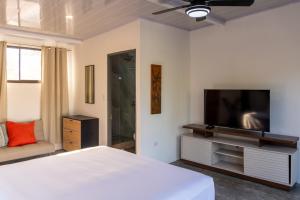 a bedroom with a bed and a flat screen tv at Nosara Hotel Playa Garza in Garza