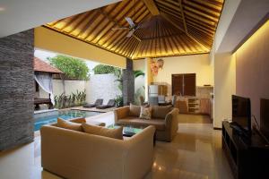 a living room with couches and a swimming pool at Lalasa Villas Canggu in Canggu