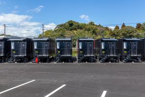 a row of portable toilets in a parking lot at HOTEL R9 The Yard Shintomi in Imabyū