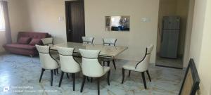 a dining table and chairs in a living room at Sakez Homestays HH in Hyderabad