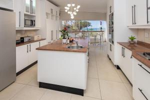 a large kitchen with white cabinets and a sink at The Beach Palace Ramsgate in Margate +139 photos