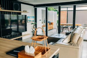 a living room with a couch and a television at 913 Luxury Pool Villa Khaolak in Khao Lak