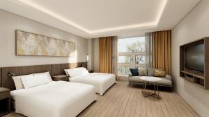 a hotel room with two beds and a flat screen tv at Charis Hotel in Incheon +42 photos