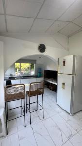 a kitchen with two chairs and a refrigerator at Casa Quinta La Jaula in Isla Paracao