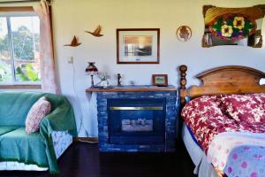 a bedroom with a fireplace and a bed and a chair at Harrison Hammond House Farmstay in Harrison Mills +37 photos