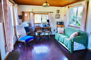 a living room with a green couch and chairs at Harrison Hammond House Farmstay in Harrison Mills