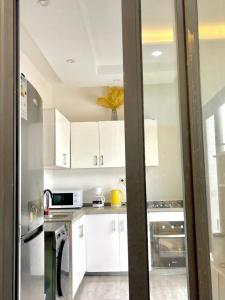 a kitchen with white cabinets and white appliances at Goat1 in Dakar