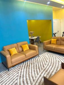 a living room with two couches and a blue wall at Goat1 in Dakar +2 photos