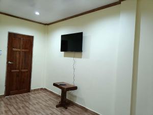 a room with a flat screen tv on a white wall at Room 5 in Siquijor