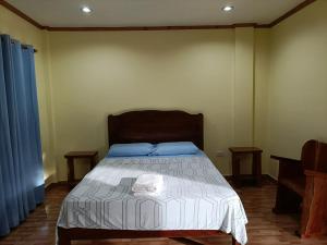 a bedroom with a large bed with blue pillows at Room 5 in Siquijor