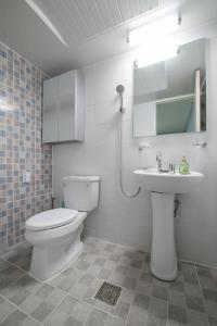 a white bathroom with a toilet and a sink at DreamTrip Guesthouse in Incheon