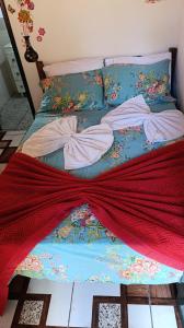 a bed with a red blanket on top of it at Chalé da Ana in Ouro Preto +15 photos