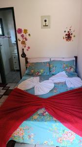 a bed with a red blanket on it in a bedroom at Chalé da Ana in Ouro Preto