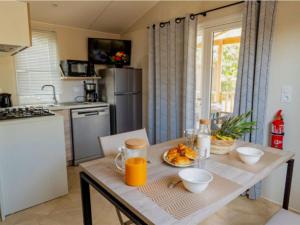 a kitchen with a wooden table with a bowl of food on it at Cottage avec clim - 4 pers. - API-1-52-2191 in Balaruc-les-Bains
