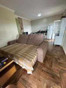 a living room with a couch and wooden floors at Sítio com piscina em bh mirante do Sol in Santa Luzia