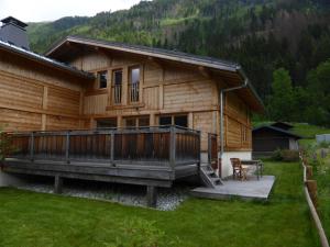eine Blockhütte mit einer Veranda und einer Terrasse in der Unterkunft Les Chalets Aquarelle in Chamonix-Mont-Blanc