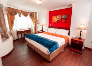 a hotel room with a bed and a red wall at Quo Vadis Hotel in Loja
