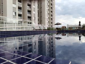 a reflection of two buildings in a pool of water at Canto da Mantiqueira - Staffy House Extrema in Extrema