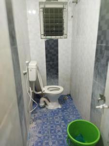 a bathroom with a toilet and a green bucket at WooLiv in Coimbatore +75 photos