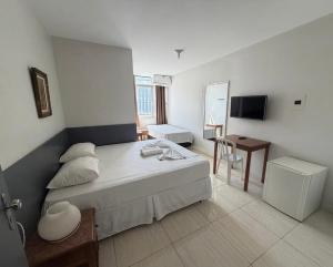 a bedroom with a bed and a desk and a television at Hotel Lords in Brasília