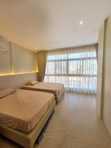 a bedroom with two beds and a large window at C Urban Villas 2 in Dau +25 photos