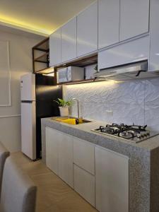 a kitchen with white cabinets and a sink and a stove at C Urban Villas 2 in Dau