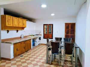 a kitchen with wooden cabinets and a table and chairs at Departamento TERRA ANDRAY centro in Famatina