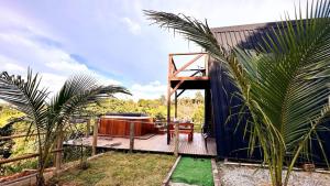 a house with a wooden deck with a bath tub at Cabana Janela do Céu in Jaboticatubas