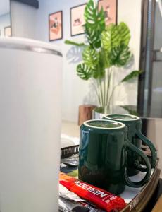 two green coffee mugs sitting on a tray at Pridi cozy home with good location Type B in Bangkok +81 photos