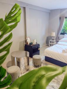 a bedroom with a bed and a table and stool at Pridi cozy home with good location Type B in Bangkok
