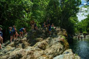 a group of people standing on rocks near a river at Beach Hub 7 Mins to Airport in Carolina