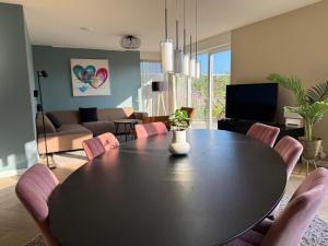 a dining room with a table and a living room at Wellness Escape with Private Sauna in Sibculo