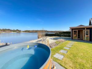 a swimming pool with a view of a lake at Wellness Escape with Private Sauna in Sibculo