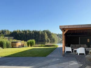 a pavilion with a table and chairs on a lawn at Wellness Escape with Private Sauna in Sibculo