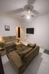 a living room with a couch and a flat screen tv at Pousada ExpoBH in Belo Horizonte
