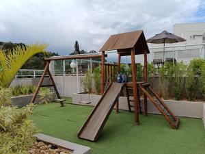 a wooden playground with a slide and an umbrella at Lua da Mantiqueira - Staffy House Extrema in Extrema