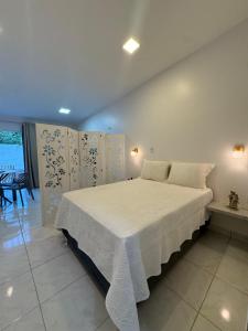 a bedroom with a large bed with white sheets and pillows at Casa aconchego do pontal in Fortim