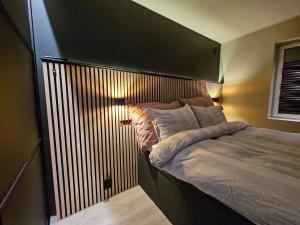 a bedroom with a large bed with a wooden headboard at Aurora Central Premium Apartment II, Bodø in Bodø