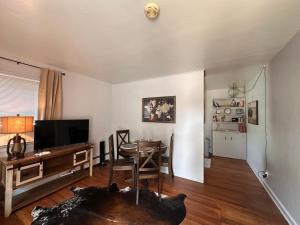 a living room with a table and a television at Pets Welcome Walkable Downtown Apt Gym & Pool Pass in Sheridan