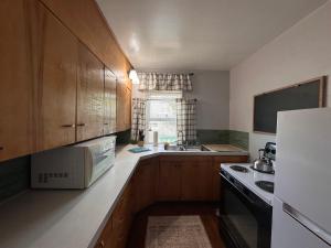 a kitchen with wooden cabinets and a sink at Pets Welcome Walkable Downtown Apt Gym & Pool Pass in Sheridan