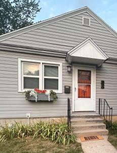 a house with a white door and flowers in a window at Pets Welcome Walkable Downtown Apt Gym & Pool Pass in Sheridan