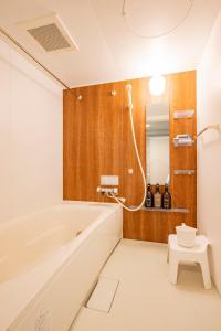 a bathroom with a white tub and a wooden wall at La Meridian Atsubetsu 401 in Sapporo +70 photos