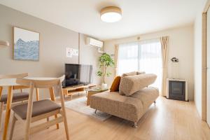 a living room with a table and a chair at La Meridian Atsubetsu 401 in Sapporo