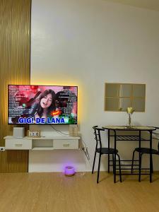 ein Wohnzimmer mit Flachbildfernseher und einem Tisch in der Unterkunft SnapStay in Magasawang
