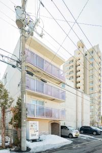an apartment building with cars parked in front of it at La Meridian Atsubetsu 401 in Sapporo